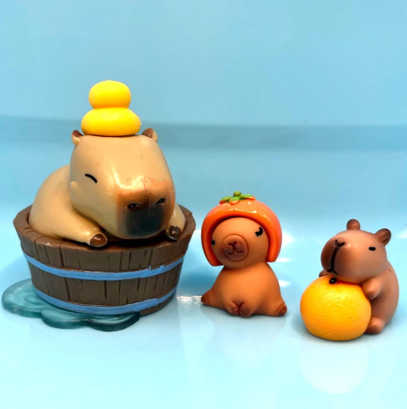 Capybara Soaking in Wooden Tub with Two Tiny Pals